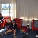 Teammates Michelle Lauer (left) and Sylvia Sarnik sit in the boathouse in the hours before making MIT history. The space has a camped-out family feel. Nervous first-year students lob earnest question at their elders: “What should I eat before the race?” (Photo: Sam Hunter Magee/Arts at MIT)