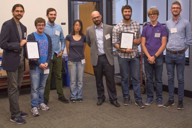 At center is Mike Tarkanian, a senior lecturer in the Department of Materials Science and Engineering and MADMEC competition organizer. Flanking him are two teams, Geoworks (left) and DUMBLEDORE (right), which split second and third place prizes of $7,000 and $5,000. (Photo: Tara Fadenrecht/DMSE)